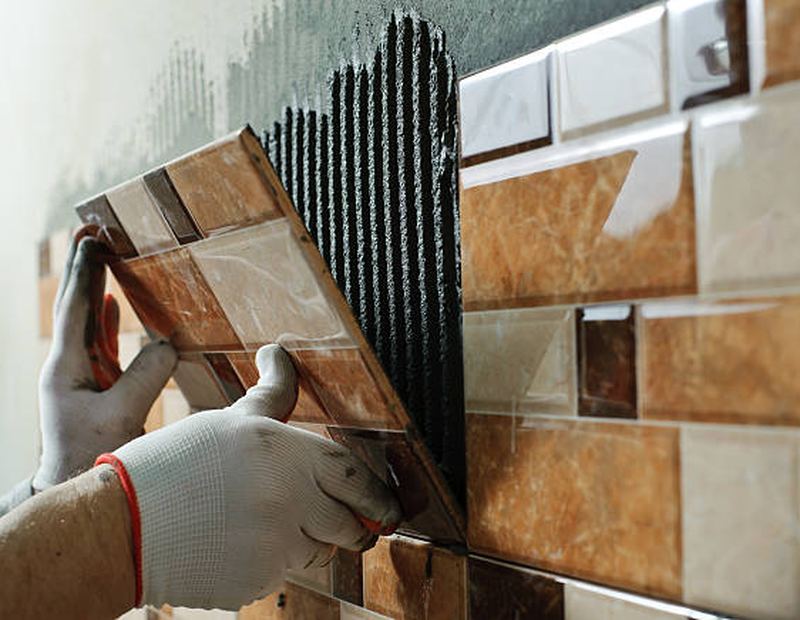 Craftsman fitting wall tiles with precision